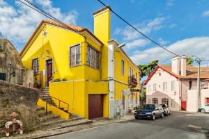 a yellow building on the side of a street at A Casa Amarela de Sintra in Sintra