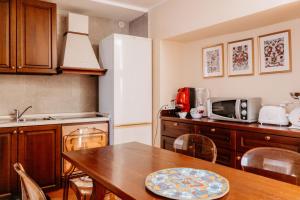 a kitchen with a wooden table and a refrigerator at A Casitta 2 Luxury Apartments in Taormina