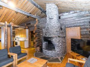 Cabaña con sala de estar con chimenea de piedra. en Holiday Home Kultarinne by Interhome, en Saariselkä
