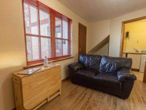 a leather couch in a living room with a window at Apartment Miller Apartment by Interhome in Inverness