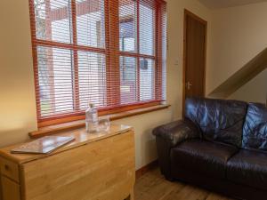 uma sala de estar com um sofá de couro e uma janela em Apartment Miller Apartment by Interhome em Inverness