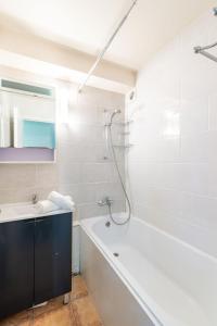 biała łazienka z wanną i umywalką w obiekcie Studio Home Club - Lavachet-12 by Interhome w mieście Tignes