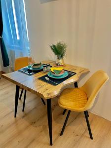 una mesa de madera con 2 sillas y una mesa con gafas en JS Design Apartment, en Graz