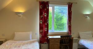 a room with two beds and a window at Glencolumbkille House - Self Catering Rooms in Glencolumbkille