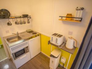 uma pequena cozinha com um lavatório e um micro-ondas em Chalet Dougie's by Interhome em Drumnadrochit