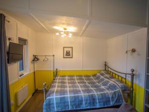 a bedroom with a bed and a flat screen tv at Chalet Dougie's by Interhome in Drumnadrochit