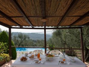 una mesa con comida bajo una pérgola en Apartment Chantal by Interhome, en Capannori