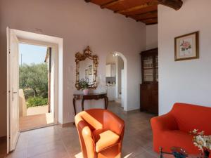 sala de estar con silla naranja y espejo en Apartment Chantal by Interhome, en Capannori