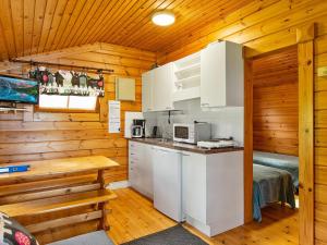 - cucina con elettrodomestici bianchi in una cabina di legno di Holiday Home Rantamökki 17 by Interhome a Karvio