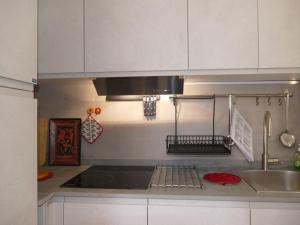 a kitchen with white cabinets and a sink and a stove at Apartment Fiori e Canzoni by Interhome in Sanremo