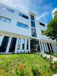 a white building with windows and a lawn at Hotel La Casona San Sebastian in Doradal +9 photos