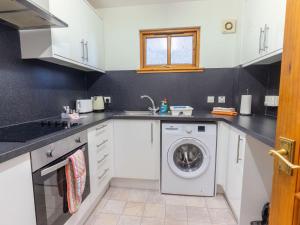 a kitchen with a washing machine and a sink at Apartment Towerhill Apartment by Interhome in Inverness