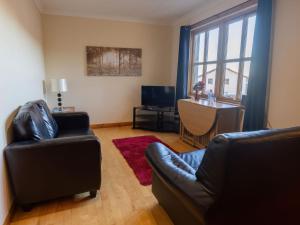 sala de estar con 2 sillas de cuero y mesa en Apartment Towerhill Apartment by Interhome en Inverness