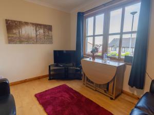 sala de estar con escritorio y ventana grande en Apartment Towerhill Apartment by Interhome en Inverness