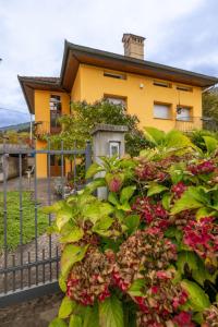 una casa amarilla con flores delante de una valla en Apartment La Corleta-1 by Interhome, en Ovaro