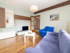 sala de estar con sofá azul y TV en Apartment La Corleta-1 by Interhome, en Ovaro