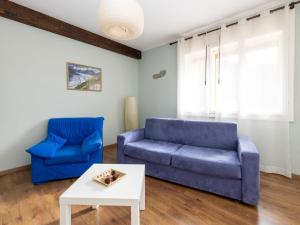 sala de estar con sofá azul y mesa en Apartment La Corleta-1 by Interhome, en Ovaro
