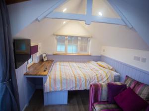 a bedroom with a bed and a desk and a tv at Chalet Affric 3 by Interhome in Drumnadrochit