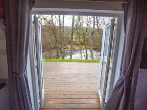 an open door to a porch with a wooden deck at Chalet Affric 3 by Interhome in Drumnadrochit