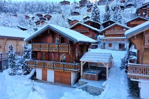 eine Blockhütte im Schnee mit Schnee in der Unterkunft Chalet individuel 8 pers à Chatel Porte du soleil avec Jacuzzi exterieur in Châtel