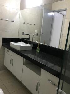a bathroom with a sink and a mirror at Pousada Linhares in João Pessoa