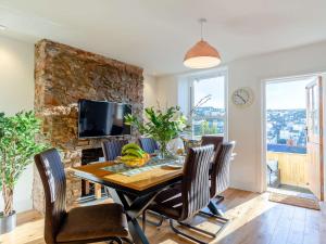 a dining room with a table and chairs and a tv at 3 Bed in Brixham 80655 in Brixham