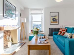 a living room with a blue couch and a table at 3 Bed in Brixham 80655 in Brixham