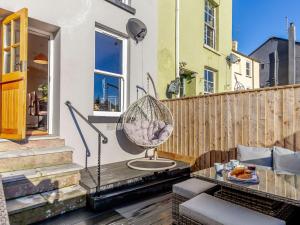 a patio with a swing and a table on a balcony at 3 Bed in Brixham 80655 in Brixham