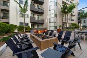 a patio with chairs and a fire pit in front of a building at MDR Studio Apartment Luxury pool, gym, parking, jacuzzi. in Los Angeles