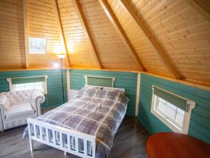 a bedroom with a bed and a chair in a room at Chalet Glen by Interhome in Drumnadrochit