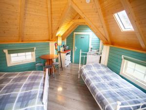 a bedroom with two beds and a table in a room at Chalet Glen by Interhome in Drumnadrochit