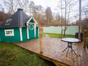 a play house with a table on a wooden deck at Chalet Glen by Interhome in Drumnadrochit