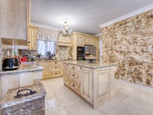 une grande cuisine avec des placards en bois et un mur en pierre dans l'établissement Holiday Home Villa Palazzo by Interhome, à Lovran