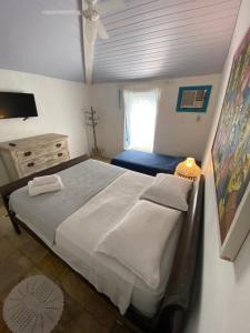a bedroom with a large bed and a window at Peixe Crew Manguinhos in Búzios