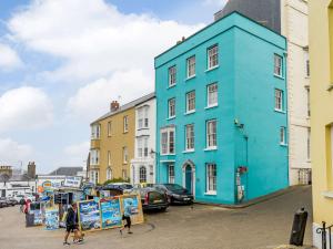 a blue building with people walking in front of it at 1 Bed in Tenby 83320 in Tenby
