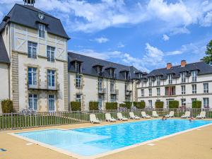 巴當的住宿－Apartment Le Château de Kergonano-12 by Interhome，大楼前设有游泳池的酒店