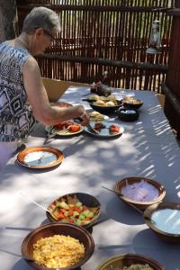 Una donna in piedi a un tavolo con piatti di cibo di Normann Safari Bush Lodge a Phalaborwa