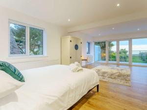a white bedroom with a large bed and windows at 4 bed in Worthing 83354 in Ferring
