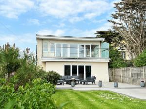 a large white house with black furniture in a yard at 4 bed in Worthing 83354 in Ferring