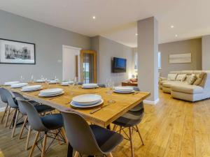 a dining room with a large wooden table and chairs at 4 bed in Worthing 83354 in Ferring