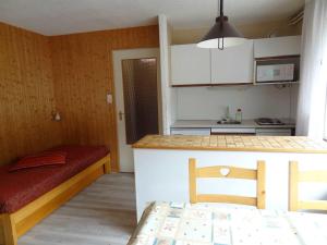 eine kleine Küche mit einem Tisch und einem Bett in einem Zimmer in der Unterkunft Studio Valloire, 1 pièce, 4 personnes - FR-1-263-38 in Valloire