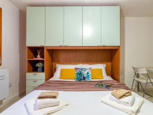 a bedroom with a bed with white cabinets and yellow pillows at Apartment 0-5-N - Marineledda by Interhome in Golfo Aranci +28 photos