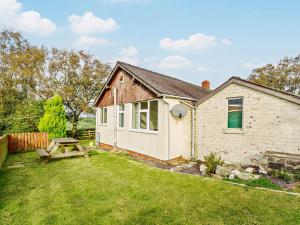 a small house with a picnic table in the yard at 2 Bed in Betws y coed 80629 in Gwytherin