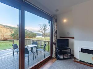 a room with a balcony with a table and chairs at Chalet Lodge 4 by Interhome in Spean Bridge
