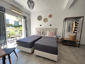 a bedroom with two beds and a balcony at Australia in Skiathos