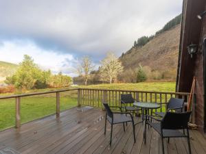 a deck with chairs and a table with a view at Chalet Lothlorien Lodge 4 by Interhome in Spean Bridge