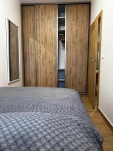 um quarto com uma cama e alguns armários de madeira em Like-a House Starówka em Plock