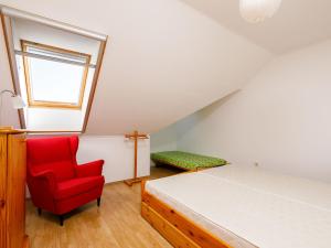 1 dormitorio con 1 cama y 1 silla roja en Apartment Pamela by Interhome, en Balatonőszöd