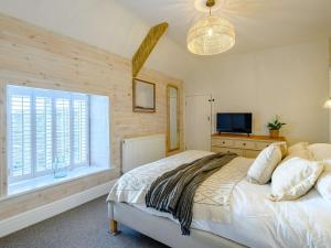 a bedroom with a bed with a television and a window at 8 bed in Southerndown 86493 in Southerndown