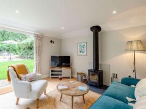 a living room with a blue couch and a wood stove at 1 Bed in Sherborne 83499 in Wincanton